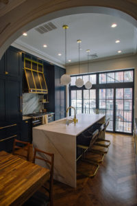 Kitchen with high ceilings, recessed lighting, french stove and vent, waterfall island